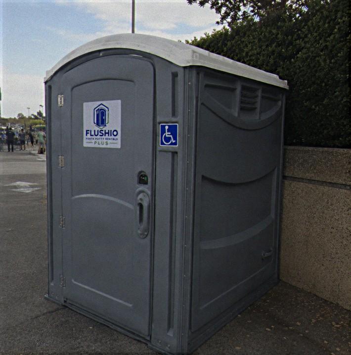 ADA accessible portable toilet rental unit with a wheelchair access decal on the side