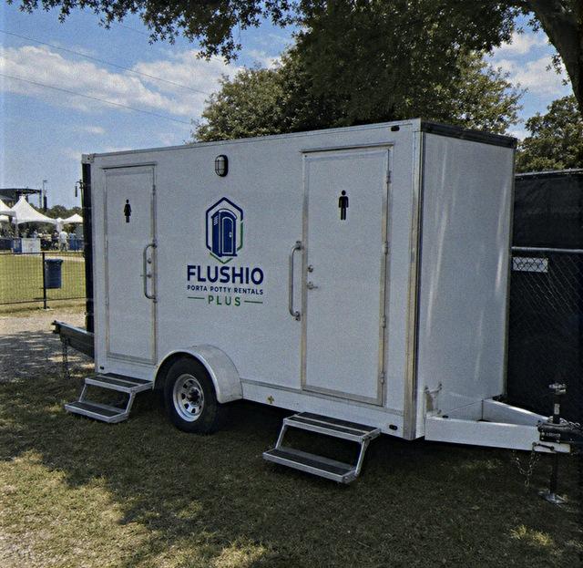 Large restroom trailer rental with separate entries parked at an outdoor event
