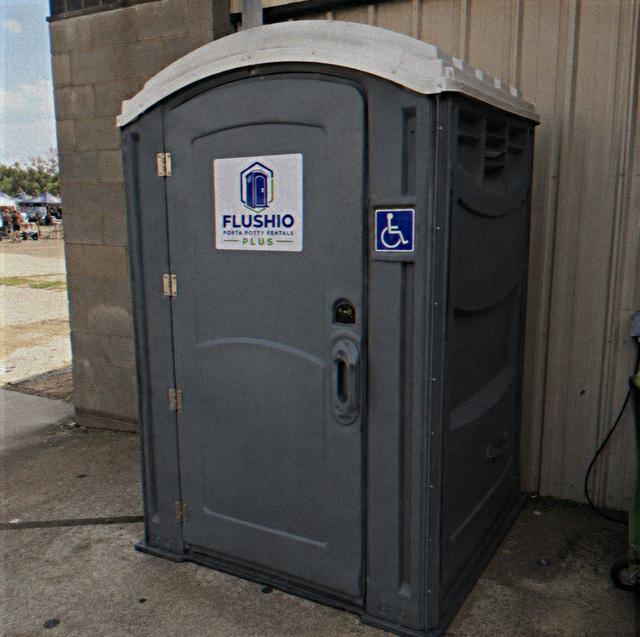 Wheelchair accessible portable toilet rental unit placed on a paved lot